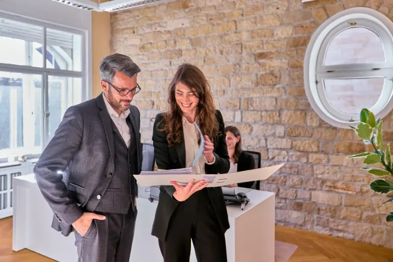 Bartz Immobilien Makler und Kundin prüfen Unterlagen im Büro – Immobilienberatung Neustadt an der Weinstraße