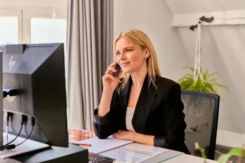 Bartz Immobilien Mitarbeiterin telefoniert im Büro – erreichbar für Ihre Immobilienfragen