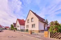 Gute Substanz, große Pläne: Einfamilienhaus mit Garten, Balkon und Garage - Straßenansicht
